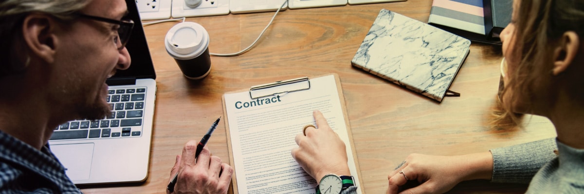 Woman Pointing Out Item on Contract Agreement to Man