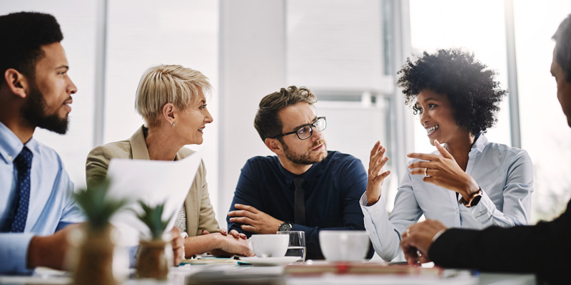 Group of Colleagues Listening Intently to Female Worker