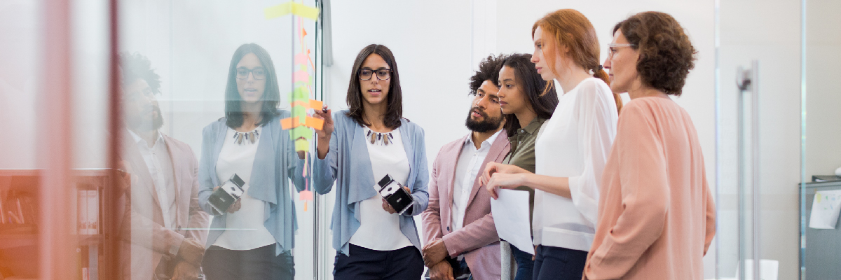 Employees Discussing Information on Sticky Notes