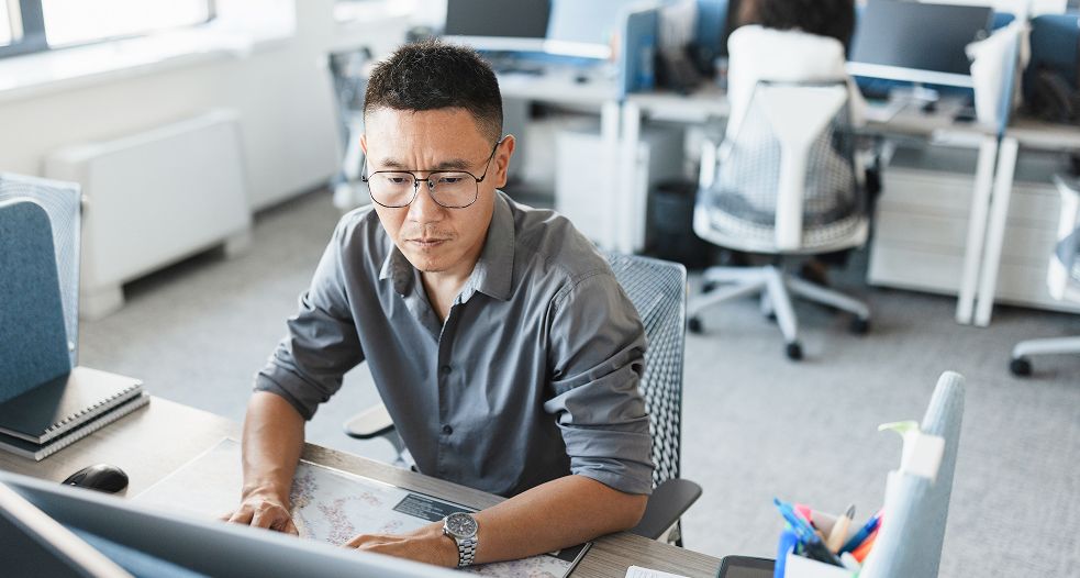 Image shows a professional man working on his laptop.