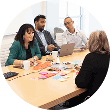 A diverse team of professionals sitting at a conference table actively collaborating