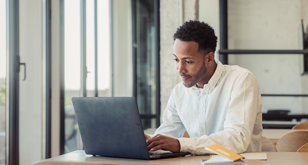 Image shows a professional man working on his laptop.
