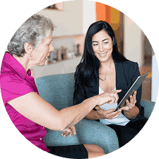 Two professional women reviewing information together on a digital tablet.