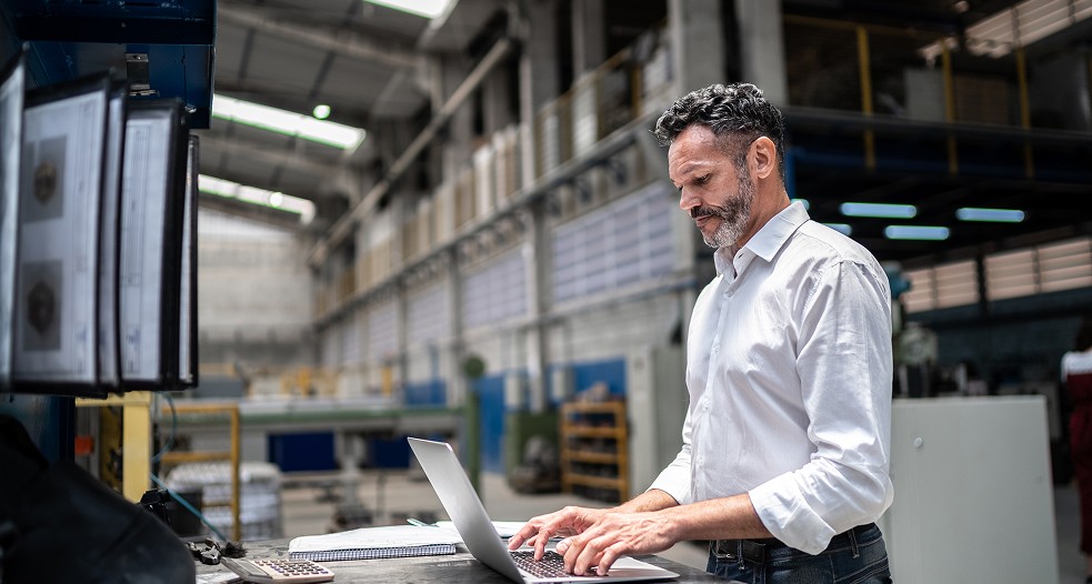 Image shows a professional man working on his laptop.